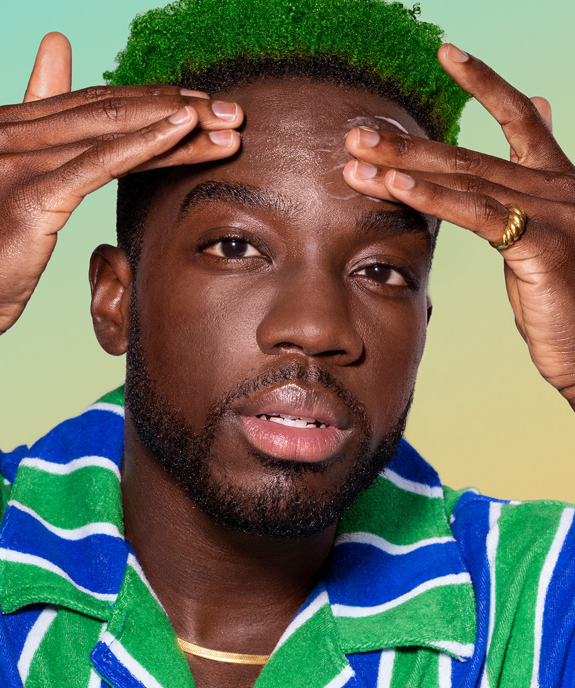 Male applying skincare product to forehead