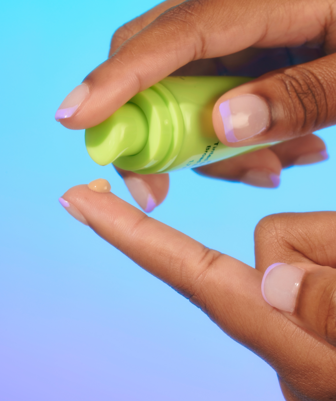 Person squeezing tinted sunscreen SPF 40 onto fingers